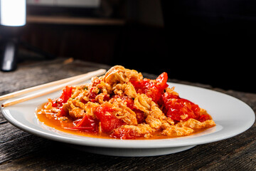 Omelette with tomatoes on a dark background.Asian food. Chinese cuisine