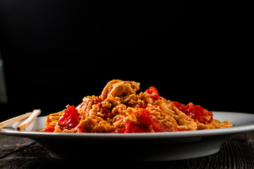 Omelette with tomatoes on a dark background.Asian food. Chinese cuisine