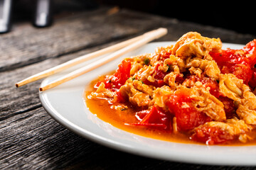 Omelette with tomatoes on a dark background.Asian food. Chinese cuisine
