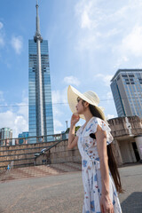 夏の福岡タワーと若い女性