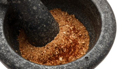 Granite mortar and pestle grinding spices and herbs closeup, culinary preparation, kitchen utensil for fresh flavors
