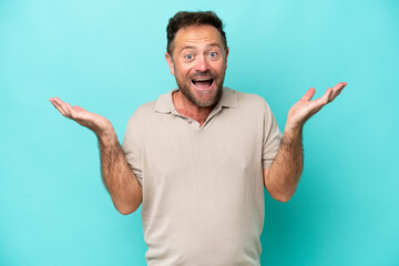 Fototapeta premium Middle age caucasian man isolated on blue background with shocked facial expression