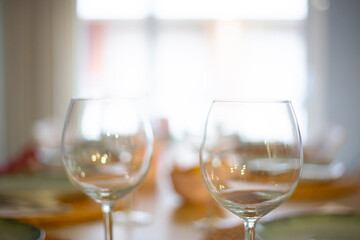 Two empty transparent wineglasses on an interior blurry scene background