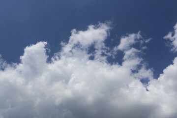 Fototapeta premium White cumulus clouds drifting across a deep blue sky