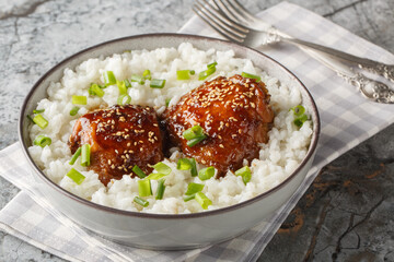Shoyu Chicken is a classic Hawaiian dish featuring tender, juicy chicken simmered in a savory-sweet shoyu soy sauce served with white rice closeup on the plate on the table. Horizontal © FomaA