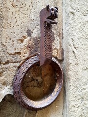 Antique iron hitching post for horses on a wall in the city of Siena, Italy