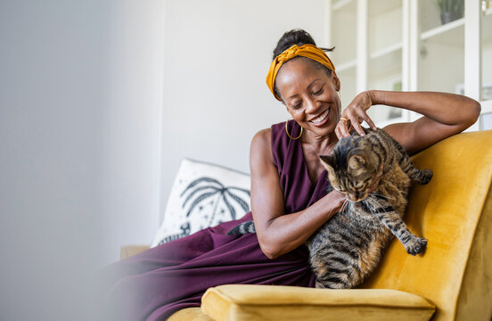 Portrait of smiling woman with her cat at home
