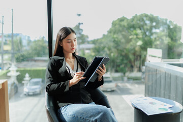 Fototapeta premium Asian office worker stressed while reviewing monthly sales report on her computer.