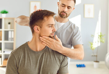 Obraz premium Masseur or therapist performs a neck massage on a patient during a rehabilitation or physiotherapy session. Physical therapy, stretching, and the medical care provided to aid recovery and relaxation.