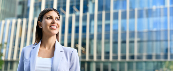 Banner with profile portrait young beautiful hispanic woman corporate leader dreaming looking at copy space. European or latin mature executive female businesswoman at office business building outdoor