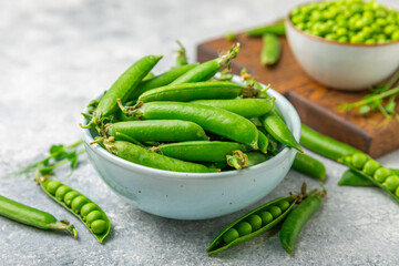 Fresh green pea pods with green peas on a wooden background. Sweet green peas. Green pea beans vegetables. Vegan. healthy vegetable. Copy space