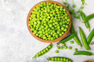 Fresh green pea pods with green peas on a wooden background. Sweet green peas. Green pea beans vegetables. Vegan. healthy vegetable. Copy space