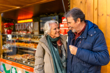 Happy senior couple enjoying christmas market festivities