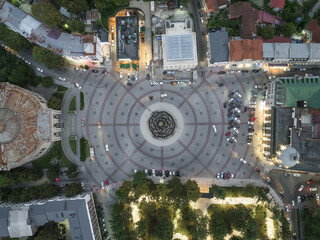 Aerial view of the vibrant heart of the city, where the intricate circular paving of the central square meets the soft glow of streetlights, Kutaisi, Imereti, Georgia.