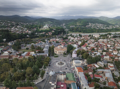 Aerial view of the vibrant city center meeting the Rioni River, the circular Colchis Fountain stands out amidst the buildings, Kutaisi, Imereti, Georgia.