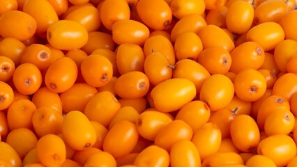 Natural sea buckthorn texture backdrop for wellness, cosmetics or nutrition themes, 16:9 authentic.