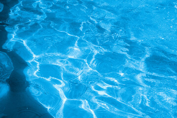 Blue water surface with sunlight reflections