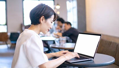 A woman working on her laptop at a cafe
