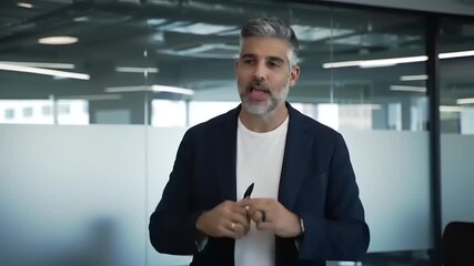 Professional man presenting ideas in a modern office setting with glass walls and urban views