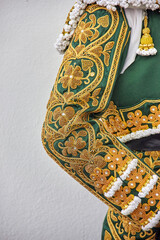 Close-up of a traditional green and gold matador costume with intricate embroidery. Practical...