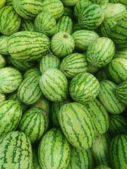 Several large sweet green watermelons. several large sweet green watermelons are placed on a wooden table on a natural background for sale.