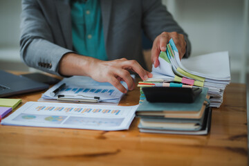 Businessman searching through paperwork and analyzing financial data