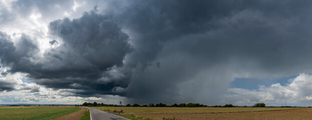 Panoramafoto eines über das Land ziehenden Unwetters mit Starkregen und dramatischen...