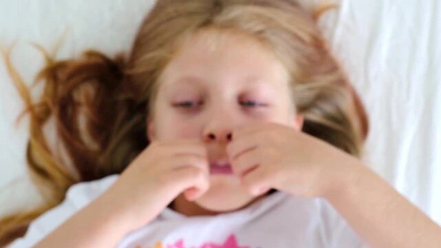 Sleeping with your mouth taped shut. Healthy sleep for children. The girl puts a Band-Aid on her mouth. The habit of breathing through your nose. The adenoid. Somnology. ENT diseases. Medical Tech