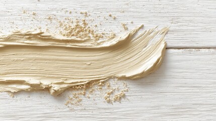 Close-up of a beige paintbrush stroke on a white wooden with textured details