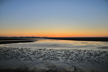 The sunset light diffusing across the mudflats