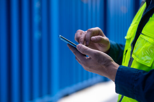 asian male engineer working with smart phone in port