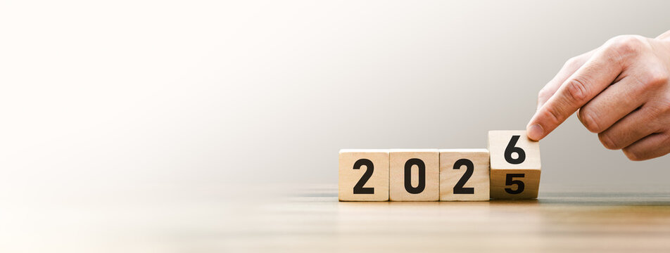 Transitioning from 2025 to 2026 with wooden blocks symbolizing target business for the upcoming year. This represents planning, investment, and innovation as ideas move from the end of 2025 new year