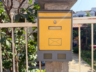 Old metal mailbox near wooden fence. Communication, correspondence, and residential lifestyle in suburban environment.