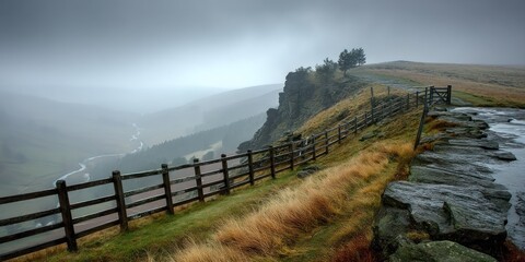 A weathered wooden fence runs along a stone path leading to a dramatic cliff edge shrouded in thick mist. The landscape is a vast, undulating moorland, partially obscured by the heavy fog. 