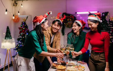 Friends toasting with wine at christmas party enjoying christmas dinner