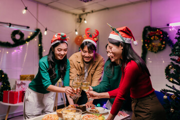 Friends toasting with white wine celebrating Christmas eve at home