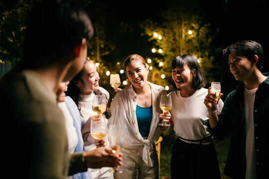 Friends enjoying drinks at a night party in the garden