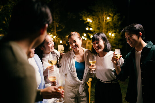 Friends enjoying drinks at a night party in the garden