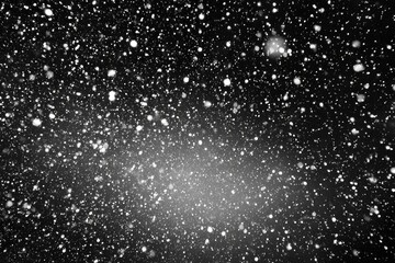 Black background densely speckled with tiny white snowflakes