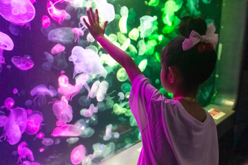 Obraz premium Young Girl Watching Jellyfish at Aquarium