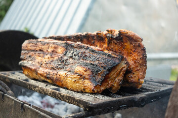 Appetizing close-up of pork ribs cooking on a grill; smoky glaze, seared crust and dripping juices emphasize flavor, texture and rustic barbecue cooking for culinary and lifestyle use