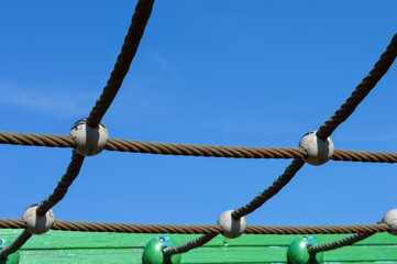 colorful playground climbing net structure with ropes and wooden frame colorful safe equipment for kids, promoting motor skills, active recreation, family leisure, urban infrastructure and outdoor fun