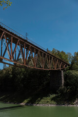 Obraz premium Steel truss railway bridge from below showing engineering details and river water