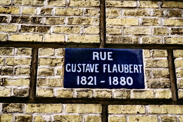 Rue Gustave Flaubert. 1821 -1880. Plaque de nom de rue. Céramique émaillée blanche et bleue sur mur de briques. 