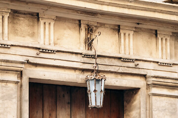 Vintage lantern hanging on aged stone building facade in central Valletta, Malta