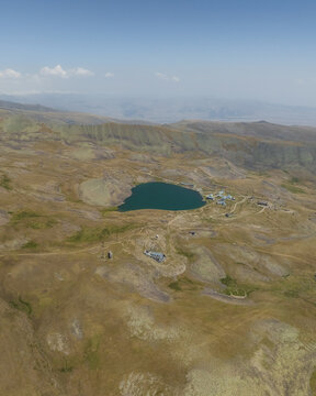 Aerial view of the serene Lake Kari mirroring the azure sky amidst the vast, arid landscape, Aragatsotn Province, Armenia.