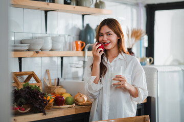 Young woman eating healthy food in kitchen