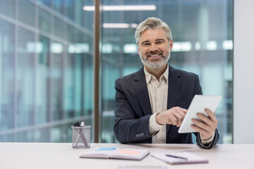 Professional man using tablet in an office environment with a pleasant smile