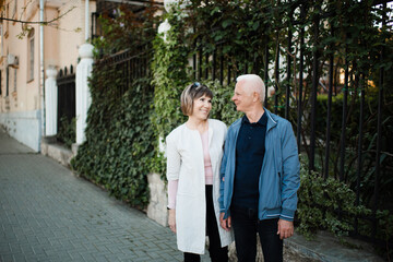 Happy romantic senior couple 55-60 year old spend time together outdoors. Retirement lifestyle. Looking at each other. Happiness.