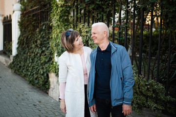 Happy romantic senior couple 60-65 year old spend time together outdoors. Retirement lifestyle. Looking at each other.